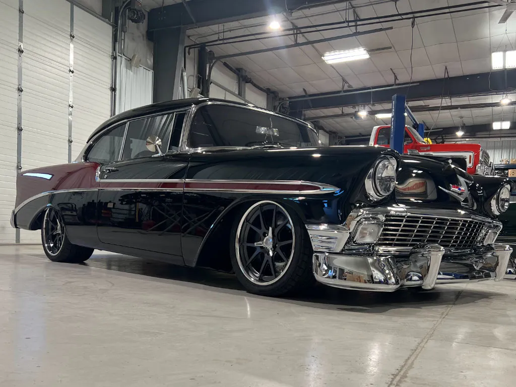 Black 1956 Chevy with red side spear and Forgeline wheels in the shop